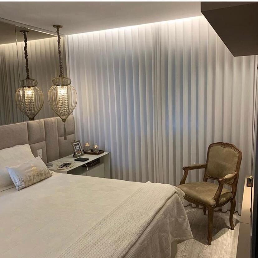 Quarto de casal com cortina em tecido leve e iluminação embutida