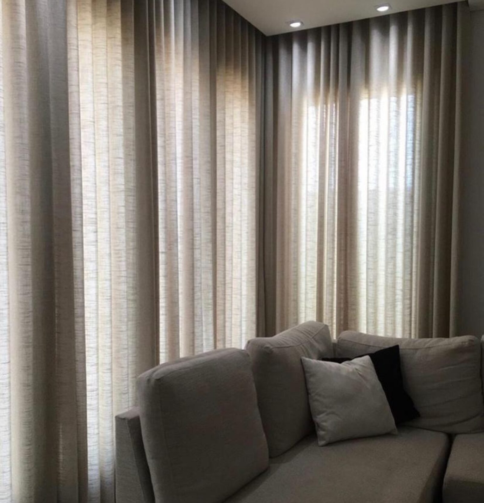 Sala de estar com cortinas em linho claro filtrando a luz natural